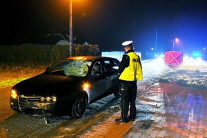 policjant i uszkodzony samochód marki Alfa Romeo