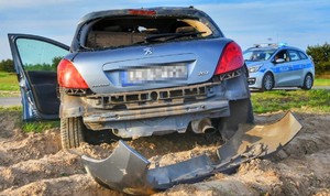uszkodzony samochód marki Peugeot i policyjny radiowóz