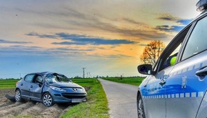 policyjny radiowóz i uszkodzony samochód marki Peugeot