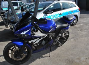 stojący na placu motocykl Yamaha i policyjny radiowóz