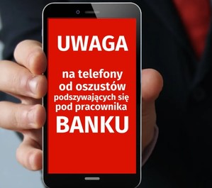 dłoń ze smartfonem z napisem UWAGA na telefony od oszustów podszywających się pod pracownika Banku